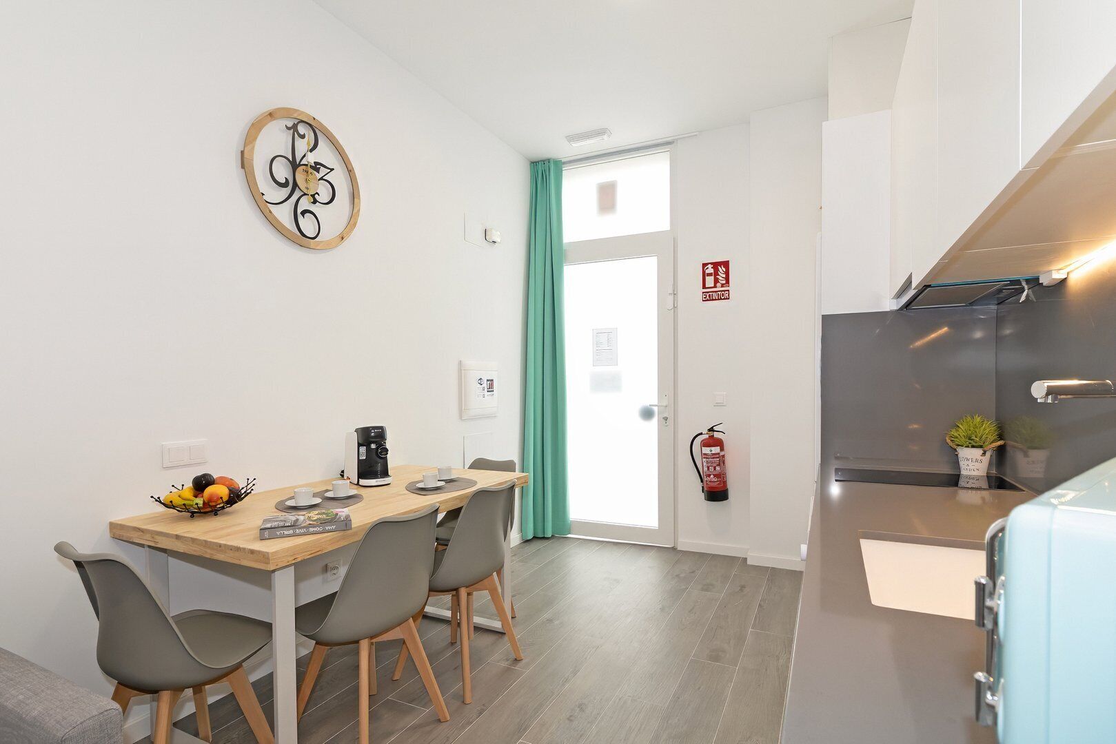 Una cocina moderna con una cafetera, un frutero y un extintor.