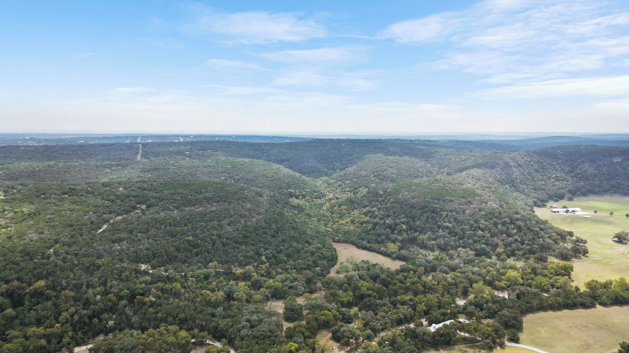 A mountainous landscape with dense forestation and a clear sky.