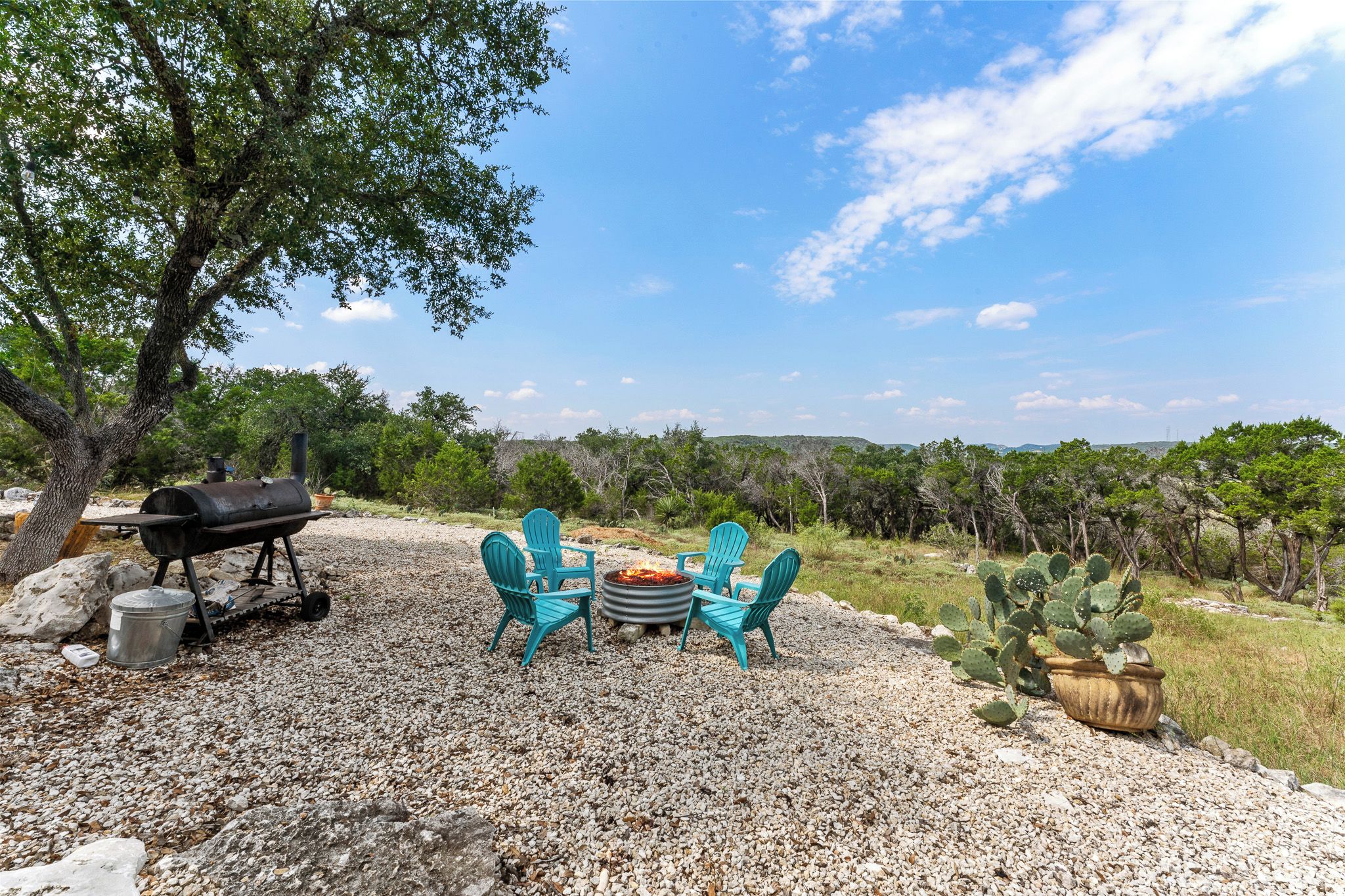 A barbecue setup with chairs and a fire pit in a natural setting.