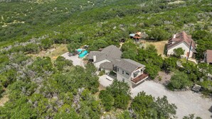 An aerial view of a residential area with multiple houses surrounded by dense greenery. - Private Pool Retreat | Romantic Hill Country Escape (New Braunfels)