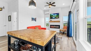 A modern kitchen with a wooden island, black metal frame, and stainless steel cookware. - Private Pool Retreat | Romantic Hill Country Escape (New Braunfels)