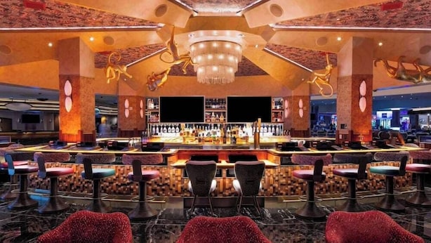 A bar area with multiple seating options and a central bar counter. - 2 Connecting Suites at a  Hotel (Las Vegas)