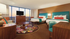 A hotel room with two beds, a TV, a desk, and a view of the city. - 2 Connecting Suites at a  Hotel (Las Vegas)