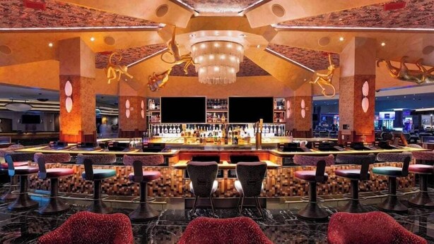 A bar area with multiple seating options and a central bar counter. - 2 Connecting Suites at a  Hotel (Las Vegas)
