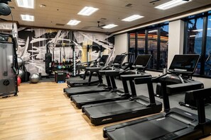 A gym with treadmills, exercise balls, and weight machines.