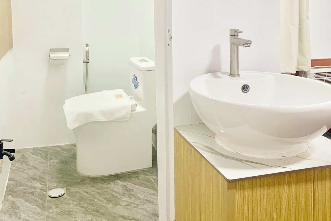 A bathroom with a white toilet, a white sink, and a marble floor.