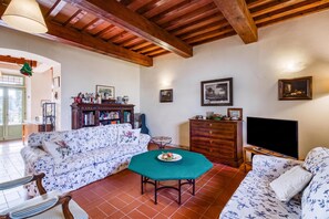A living room with a sofa, a television, a wooden cabinet, and a bookshelf. - Villa Salivolpe Amazing Chianti View 8, San Casciano VDP, Italy (San Casciano VDP)