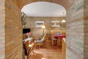 A rustic dining area with brick walls, wooden furniture, and a brick archway. - Apt Ciclamino Shared Pool & Activities in Tuscany, Montaione, Italy (Montaione)