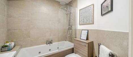 Un baño moderno con bañera, inodoro y tocador.
