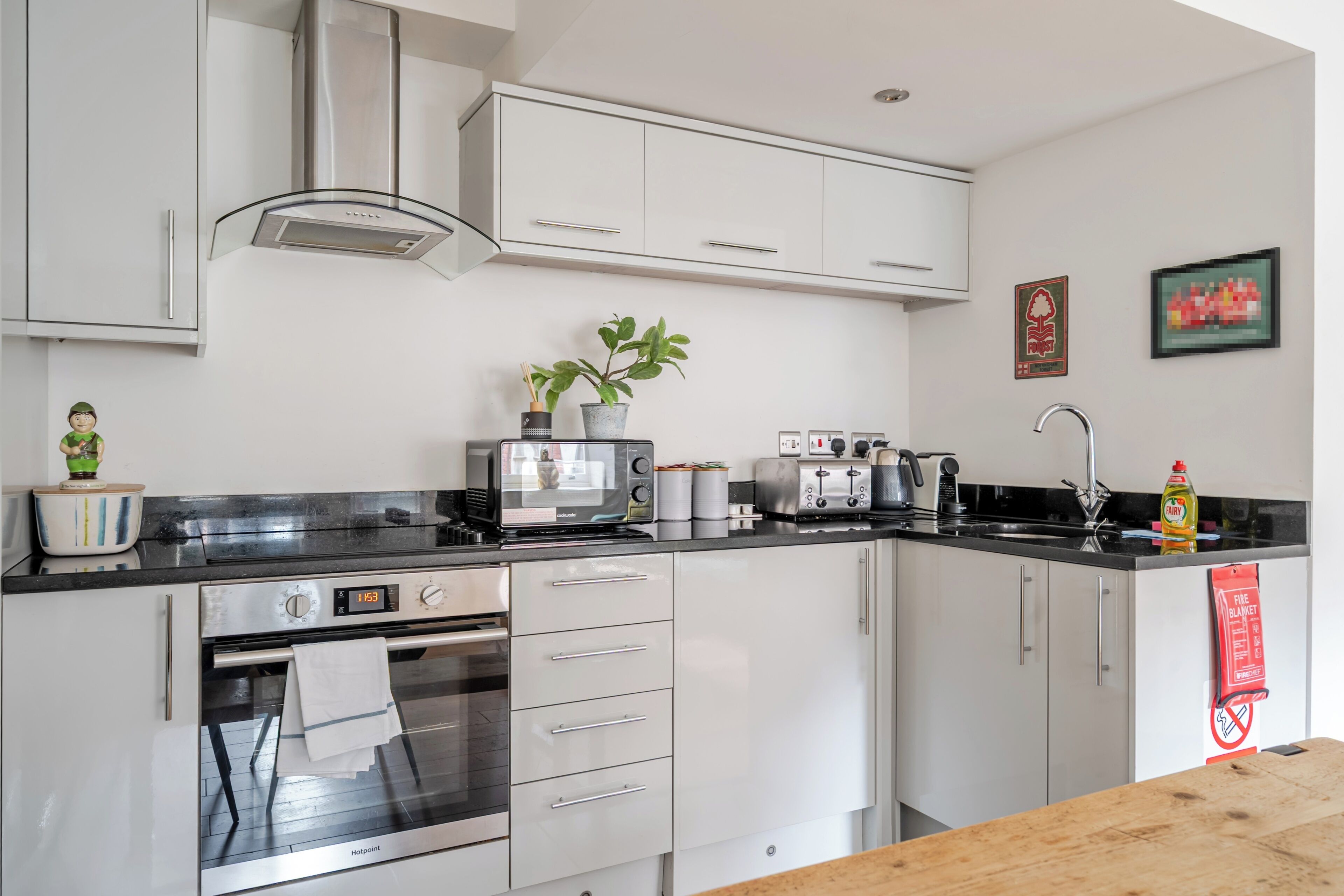 A modern kitchen with white cabinets, a microwave, toaster, and a stove.