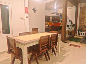Un comedor con una mesa rectangular y seis sillas de madera con respaldo trenzado.