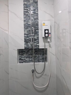 A bathroom with a shower, a control panel, and a tiled wall. - DANU COCO Pool Villa (Ko Pha-ngan)