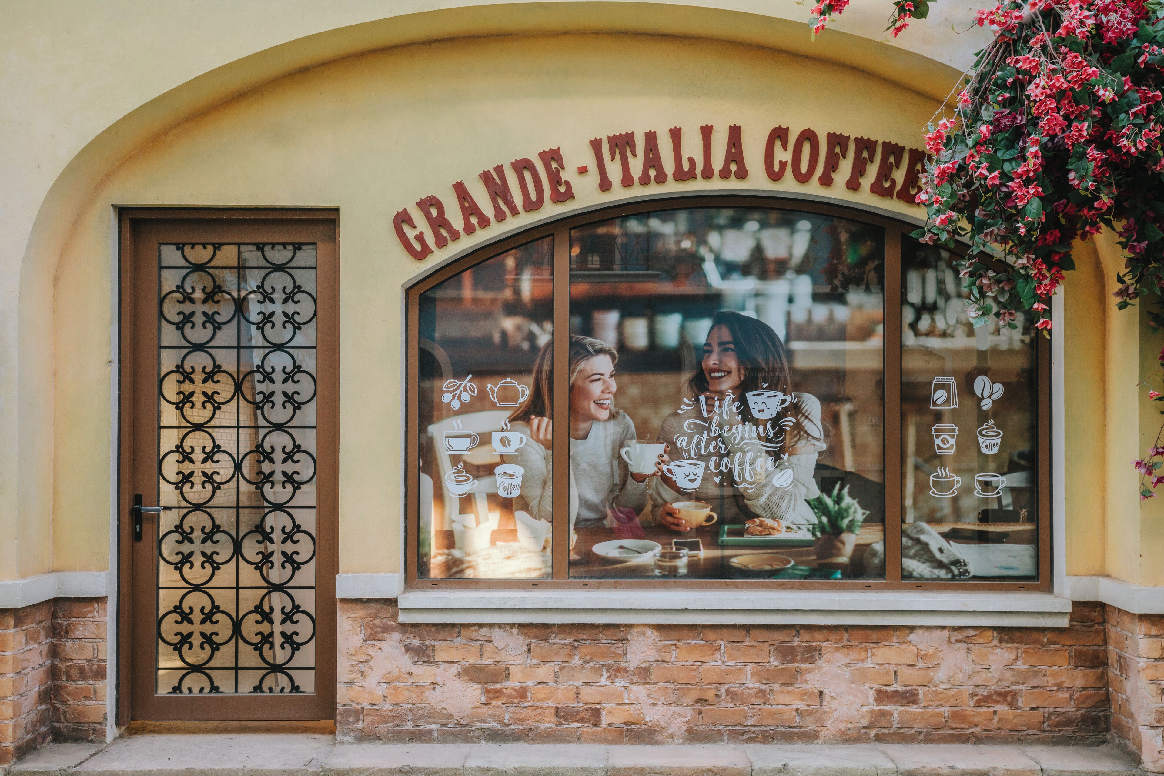 A cafe named 'Grande Italia Coffee' with a brick facade and a decorative window display.
