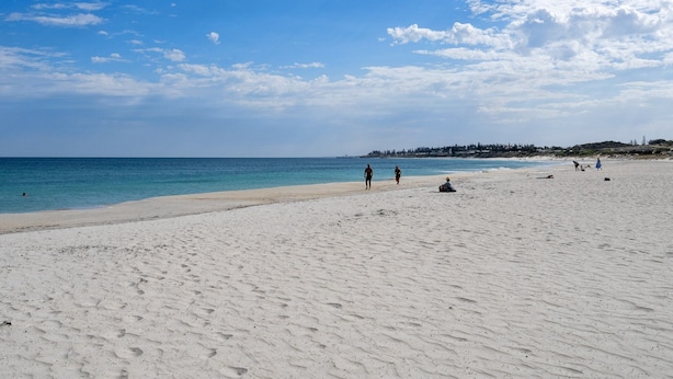 A wide sandy beach with a clear blue sky and calm sea. - Modern Studio With Rooftop and BBQ Access (Perth)