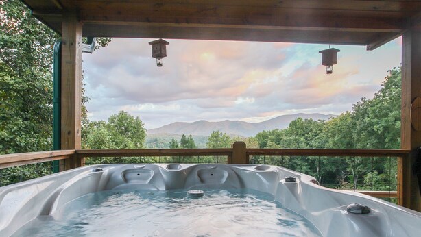 Un jacuzzi con vistas a montañas y árboles.