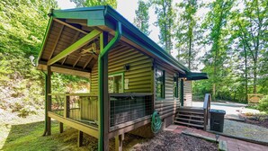 A rustic cabin with a porch, a small deck, and a covered outdoor area. - Starry Night- Honeymoon Cabin| Hot Tub| Near GSMNP (Bryson City)