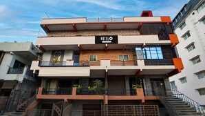 A multi-story hotel with a sign reading "HOTEL O". It has balconies, a staircase, and a gated entrance. - Classic Sri Sai Guru Comfort (Bengaluru)
