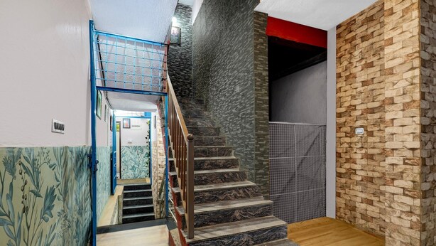 A staircase with a wooden floor and a stone wall. - Classic Sri Sai Guru Comfort (Bengaluru)
