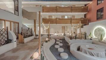 A modern interior with a central courtyard, seating areas, and a dining space.
