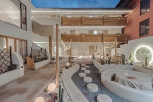 Un interior moderno con un patio central, zonas de estar y un comedor.