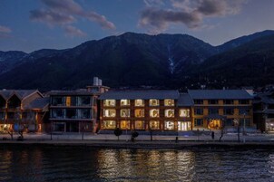 Un hotel con varias edificaciones, vista al mar y montañas al fondo.