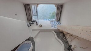 A modern bathroom with a bathtub, a shower area, and a view of the water outside. - Lugu Lake September Sky Stay (Ninglang)