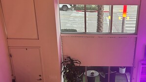 A modern living room with a sofa, a flat-screen TV, a coffee table, and a potted plant. - Cozy 1-bedroom condo loft with fitness room, AC in awesome LA/LAX/Beach (Los Angeles)