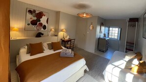 Et hotelværelse med seng, sengeborde, skrivebord og garderobeskab.