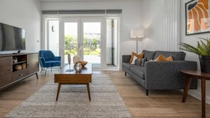 Ein modernes Wohnzimmer mit einer Couch, einem Couchtisch und einem Fernseher.