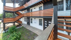 Un edificio de varios pisos con una escalera de madera y un letrero que dice "TISSERACT".