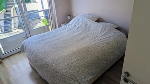 Makuuhuoneessa on sänky, yöpöytä, ikkuna, josta on näkymä ulos, ja ovi.