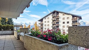 Un hôtel doté d’un balcon, d’un parterre fleuri et offrant une vue sur la montagne.