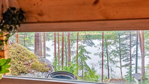 Una cabaña de madera con vistas a un bosque y un lago.