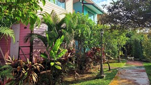 A pink house with a garden and a pathway. - Ban Roi Pah (Khlong Luang)