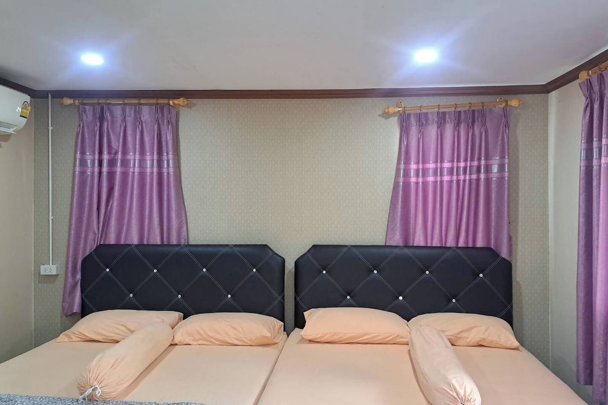 Una cama doble con cabecera, dos almohadas y una manta.