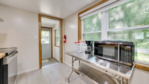 A modern kitchen with a stainless steel countertop, a built-in microwave, and a coffee maker. - Lakefront Getaway, 2-bedroom house with kayaks and deck (East Tawas)