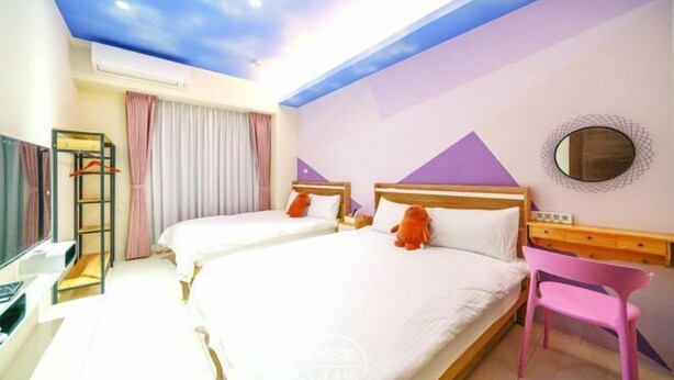 A hotel room with two beds, a TV, a desk, and a pink chair. - NEAR HOMESTAY (Yilan)