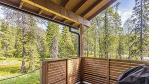 Eine Holzterrasse mit Blick auf einen Wald.
