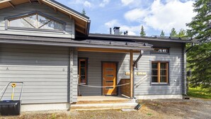 Ein zweistöckiges Haus mit Veranda, einer Holztür und einer Namensschild, auf dem 'Rusty' steht.