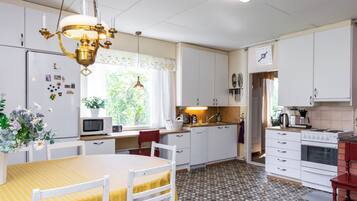 Een koelkast, een magnetron, een vaatwasser, kookgerei, borden en bestek