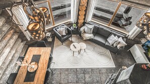 Ein modernes Interieur mit einem Holzesstisch, einer Couch und einem Kamin.