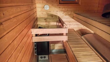 Un sauna en bois, avec des bancs, une petite fenêtre et un panneau de commande.