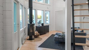 Un intérieur moderne avec une cheminée, un escalier et un coin salon.