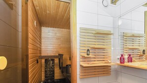 Ein Saunaraum mit Holzsitzbänken, einer Sitzbank und einem Spiegel.