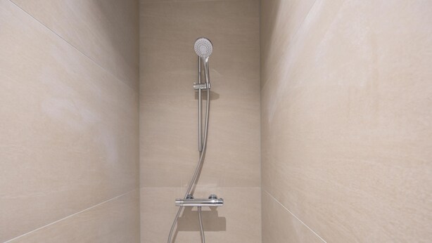 A shower with a handheld showerhead and a handheld hose. - Modern, bright studio near the sea (Middelkerke)