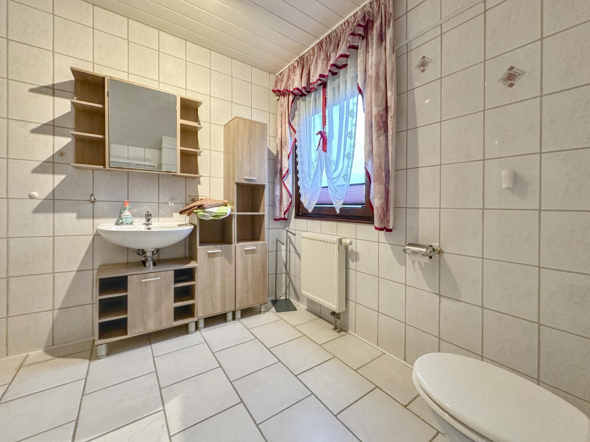 Moderni kylpyhuone, jossa on pesuallas, peili ja wc.