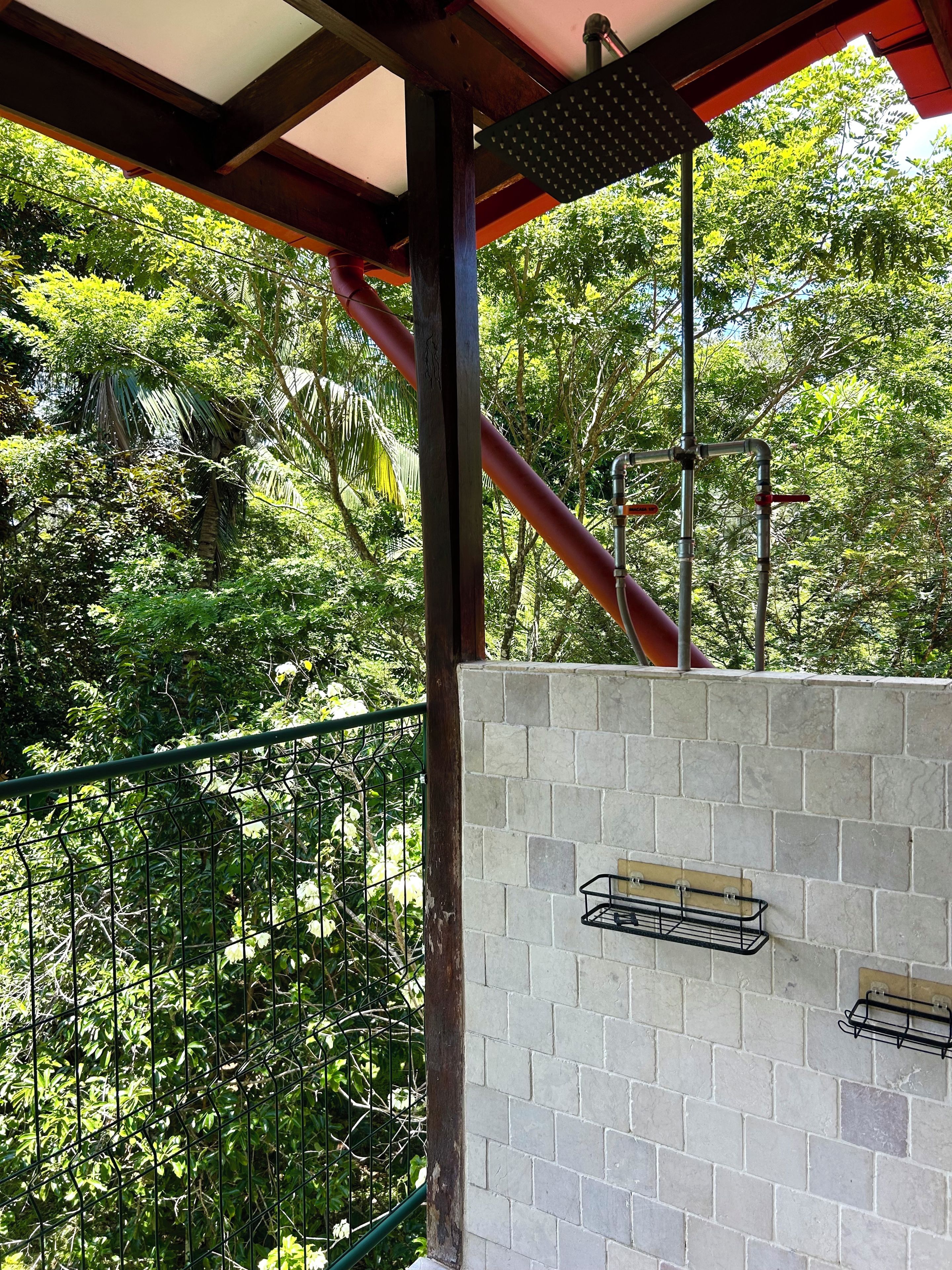 Open-air rainforest shower with spa-like tropical views