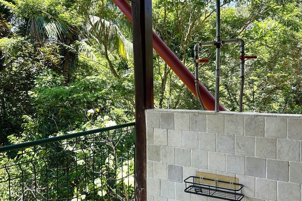 Open-air rainforest shower with spa-like tropical views