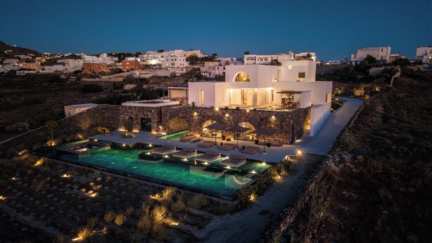 A modern villa with a pool, stone walls, and a terrace. - Charisma Estate Villa (Oia)