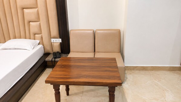 A hotel room with a bed, a wooden table, and a sofa.